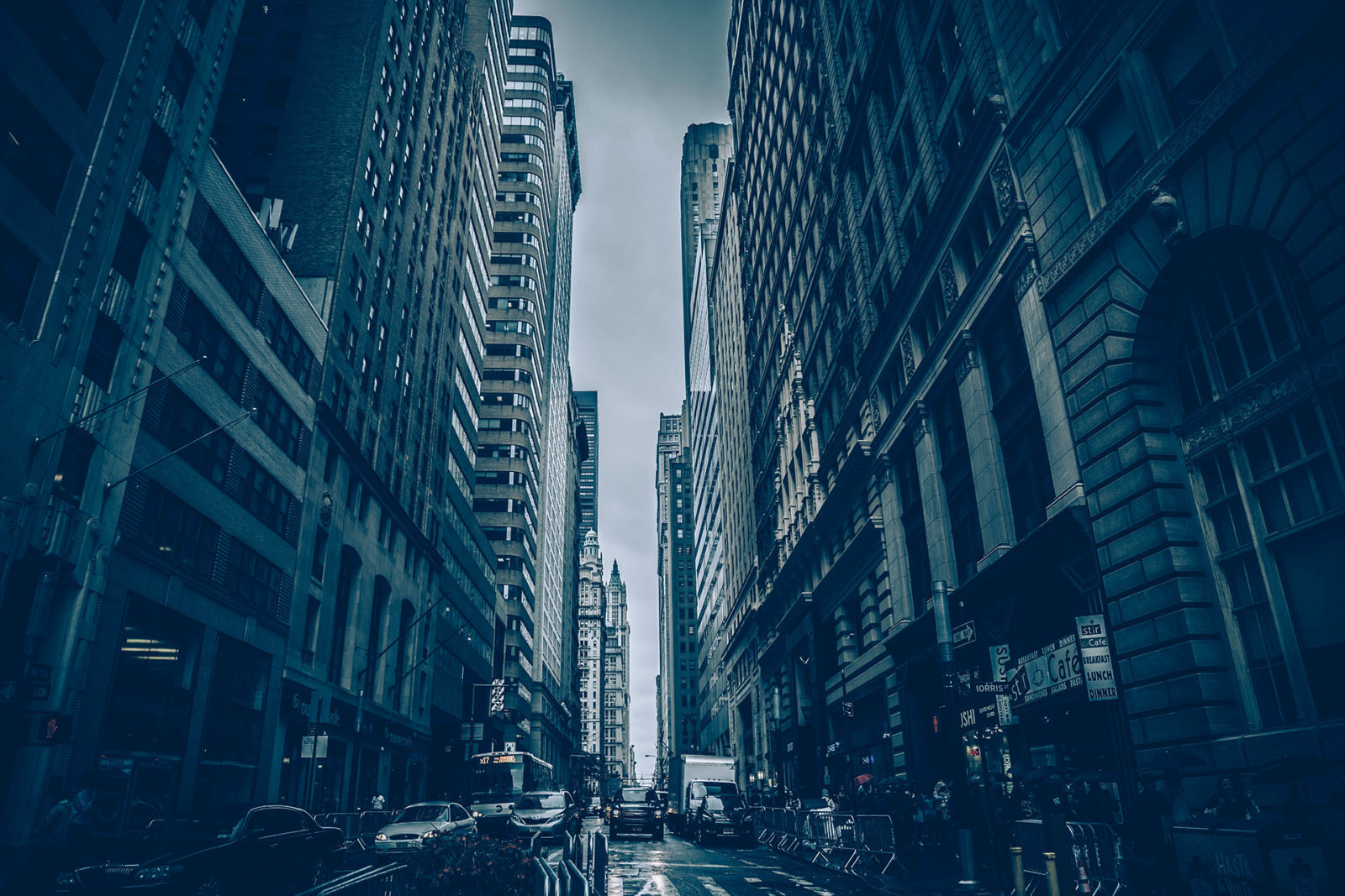 A city street with tall buildings and cars driving down it.